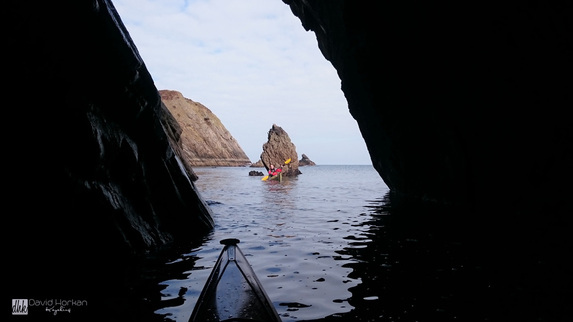 Sea kayaker explores a sea cave in Erris Co.Mayo