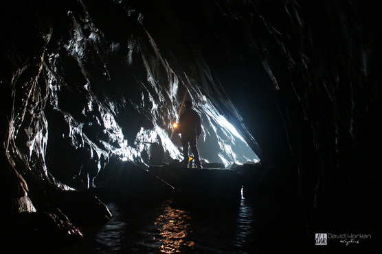 Sea kayaker explores a deep sea cave near Erris Head